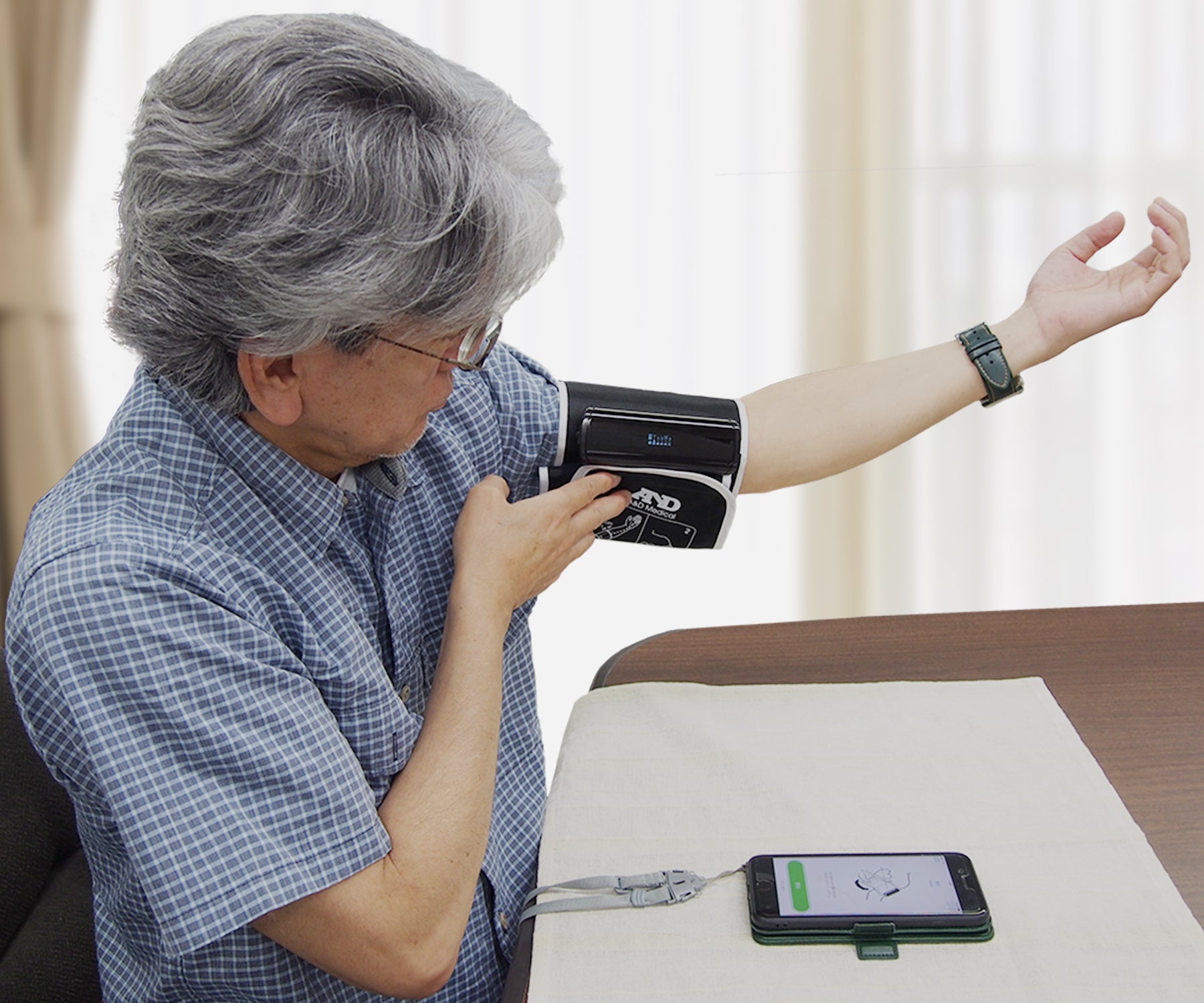 血圧計を装着している男性の画像